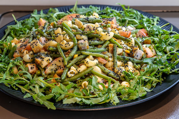 una bandeja de brócoli se sienta en una mesa junto a otros platos de comida