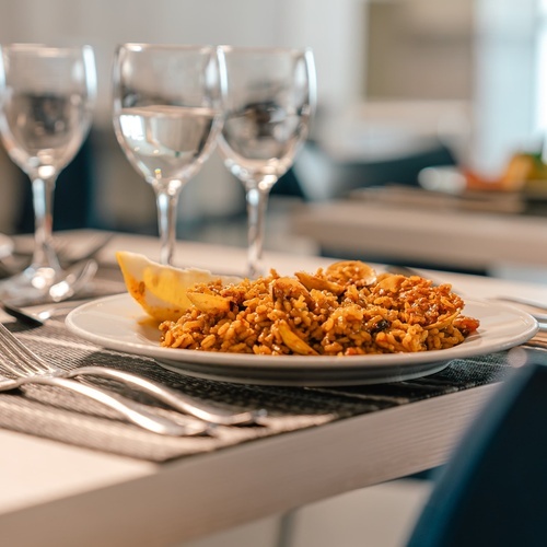 a plate of food sits on a table next to wine glasses