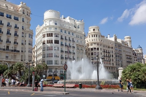 a fountain in the middle of a city surrounded by buildings