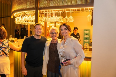 un hombre y dos mujeres posan para una foto en un restaurante - 