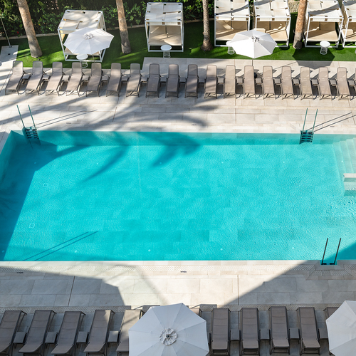 una gran piscina rodeada de sillas y sombrillas