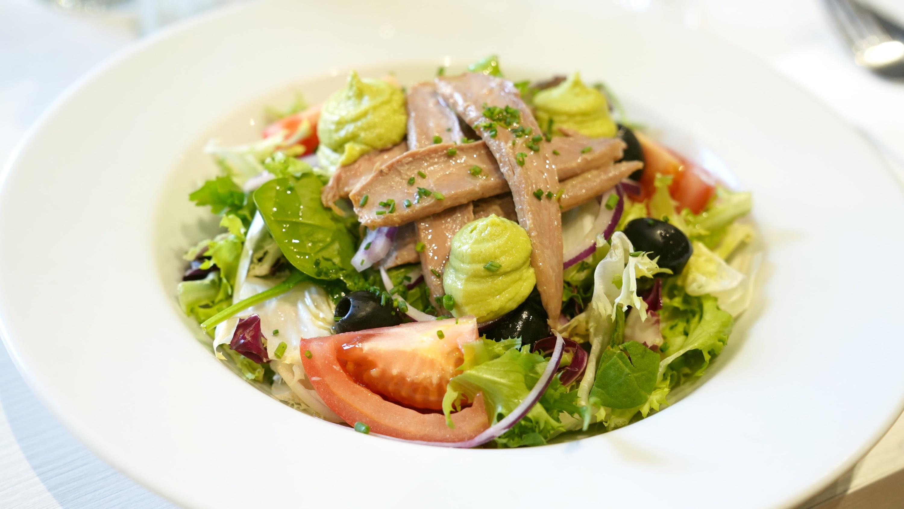 un primer plano de un plato de ensalada con atún y verduras