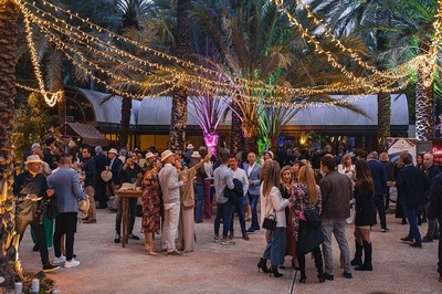 a crowd of people are gathered under a string of lights - 