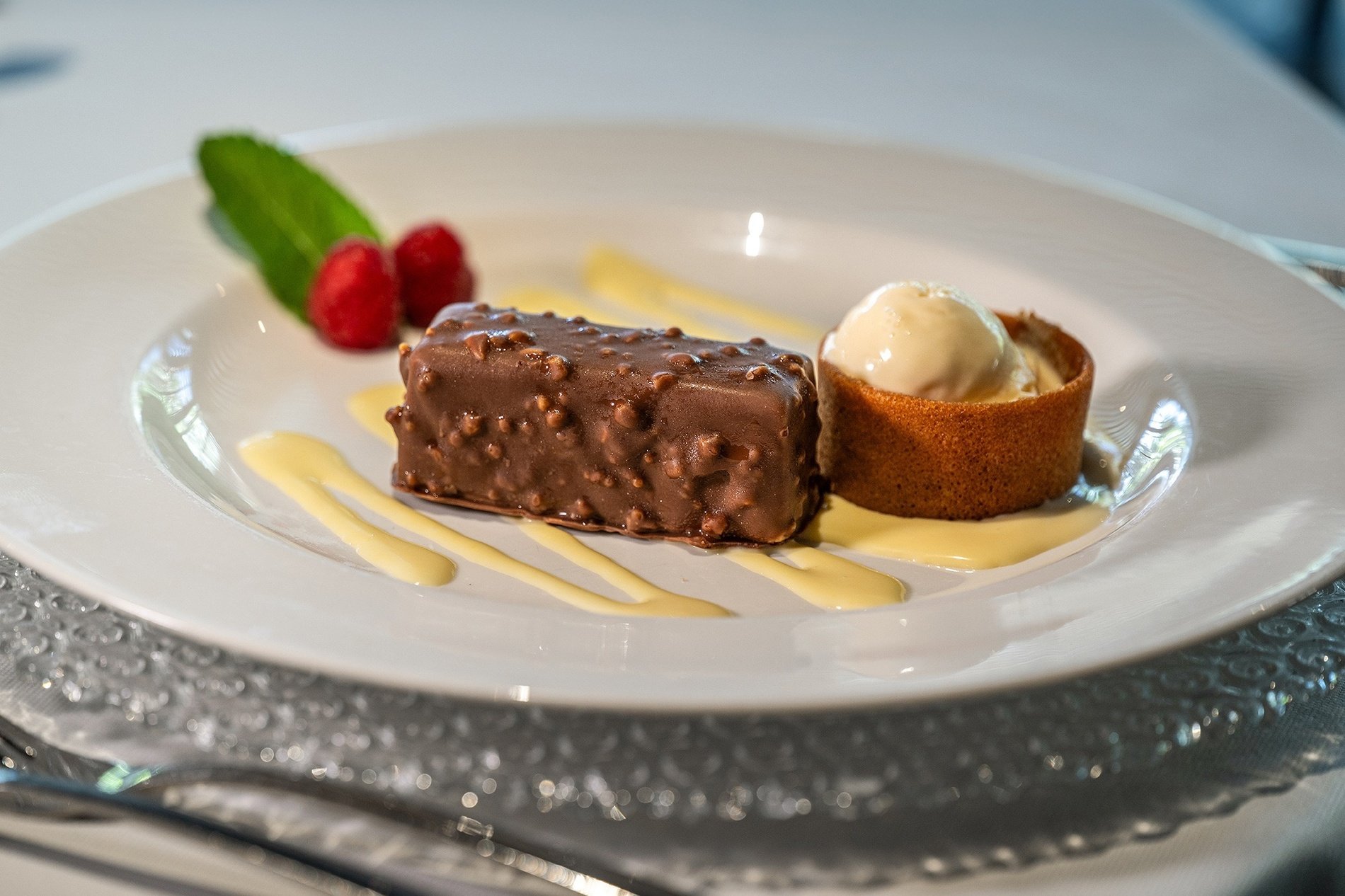 a white plate topped with a chocolate dessert and ice cream