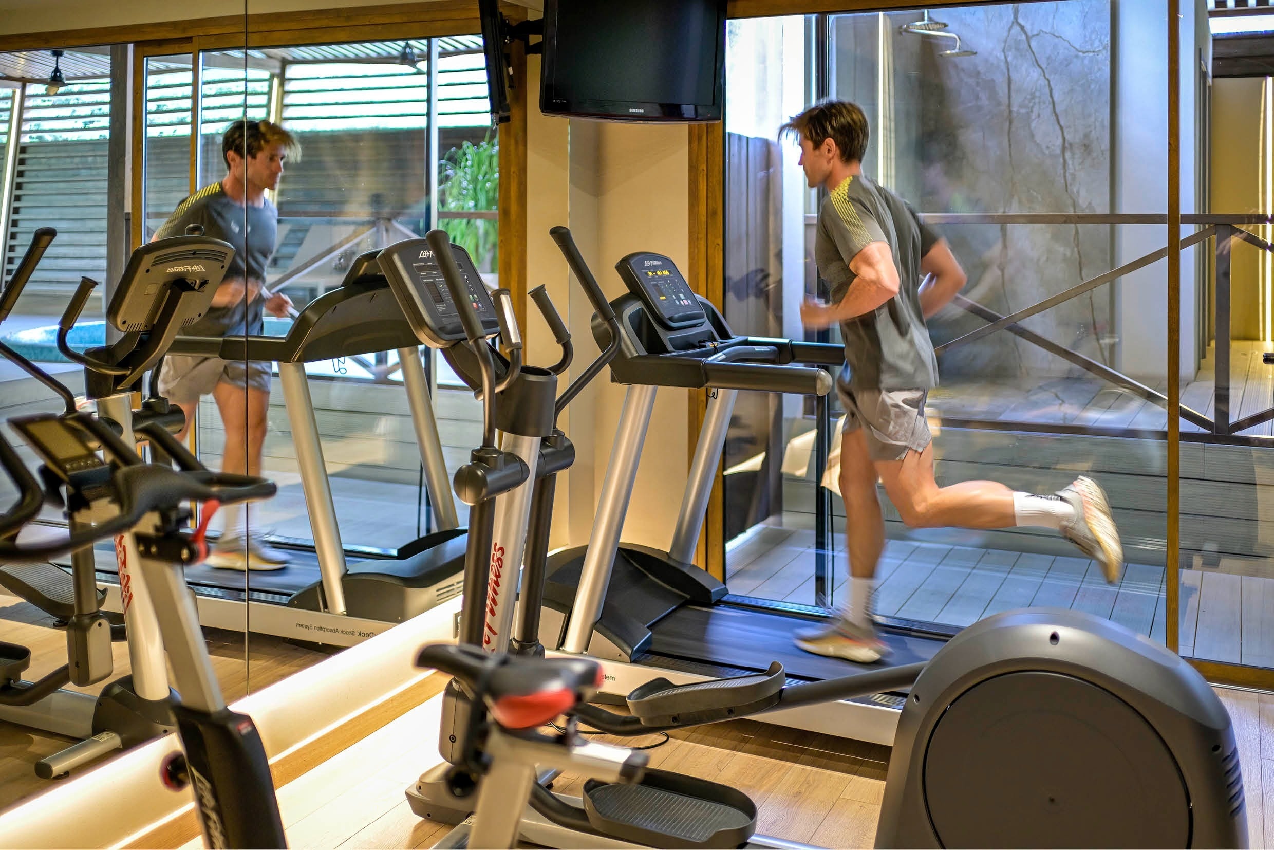 a man is running on a treadmill in a gym
