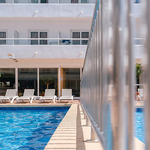 Port Hotels: Corporativa: Piscina e espreguiçadeiras em hotel com varandas brancas.
