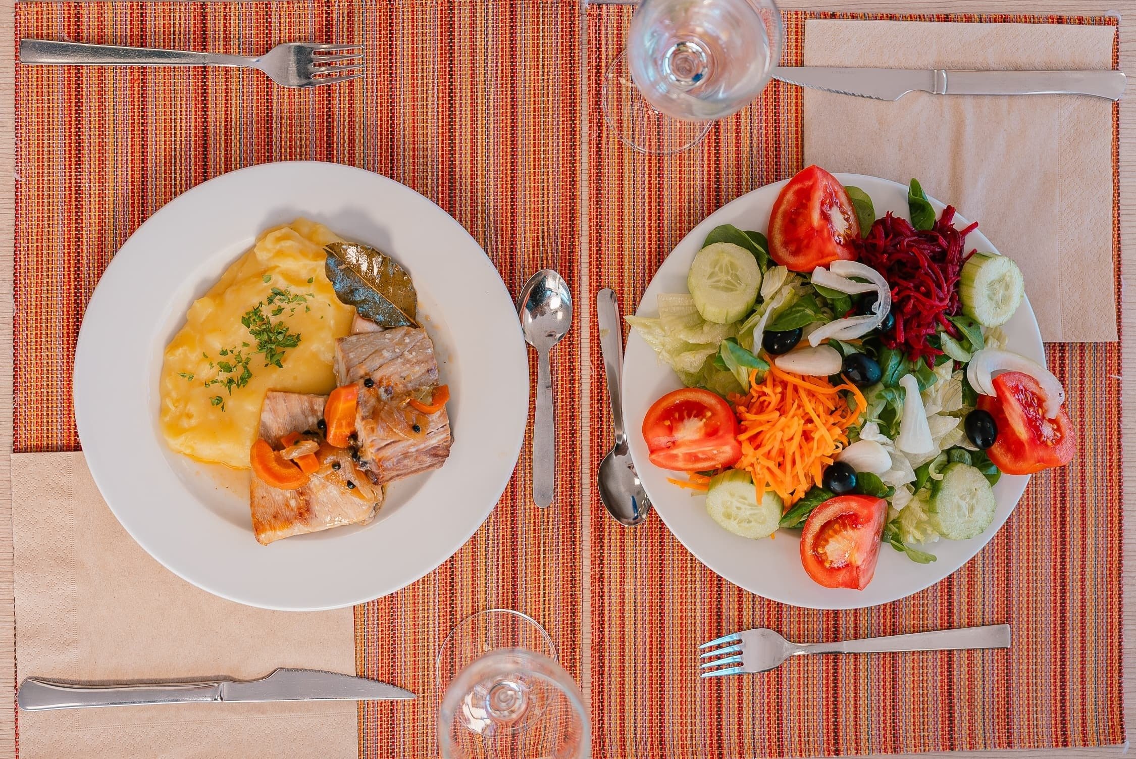 un plato de pescado y un plato de ensalada están sobre una mesa