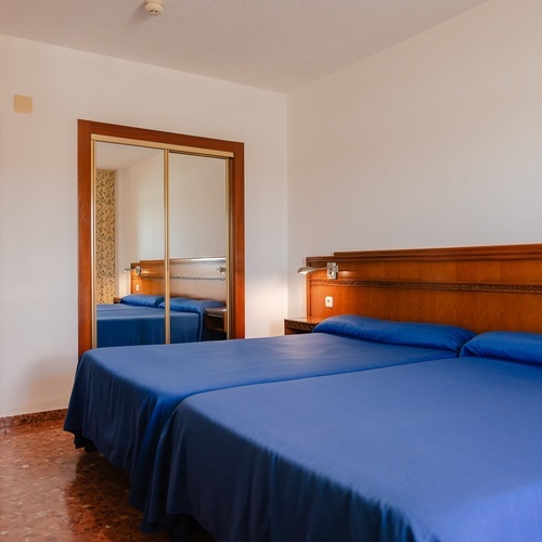 a hotel room with two beds and a mirror