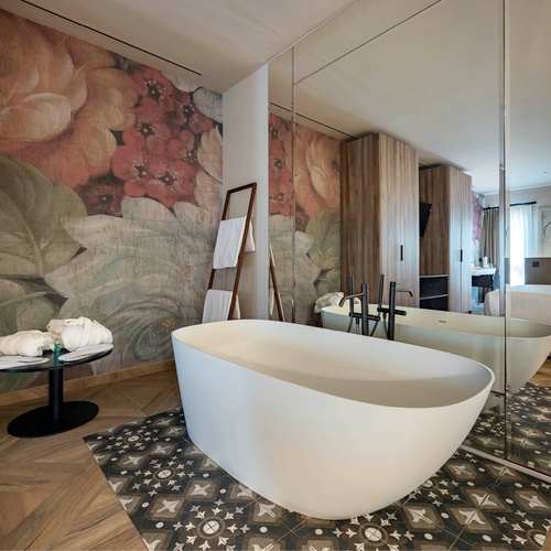 a bathtub in a bathroom with a floral wallpaper on the wall