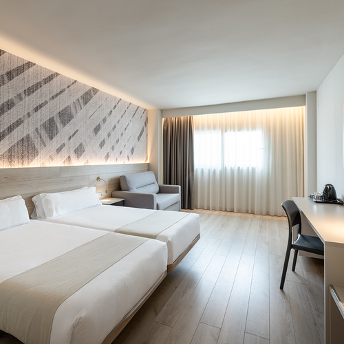 una habitación de hotel con dos camas y una televisión