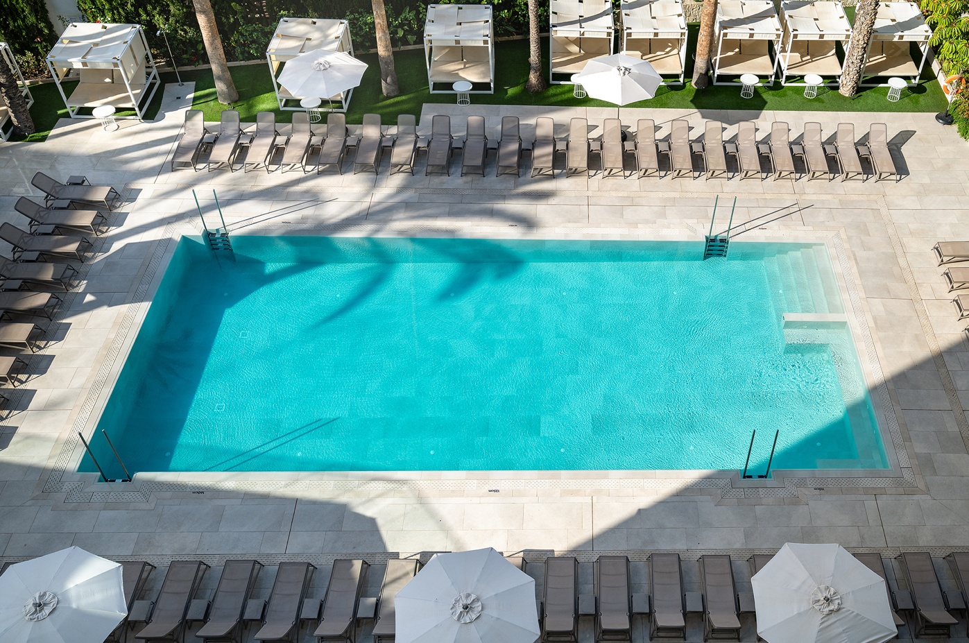 una gran piscina rodeada de sillas y sombrillas