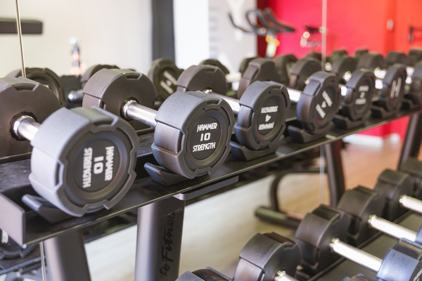 un gimnasio con mancuernas y una cinta de correr