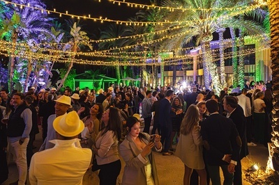 a crowd of people are gathered under a string of lights - 