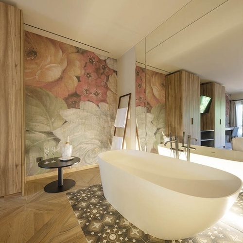 a bathtub in a bathroom with a floral wallpaper on the wall