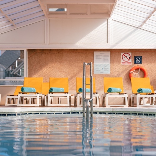 una piscina cubierta con sillas amarillas y una señal que dice no fumar