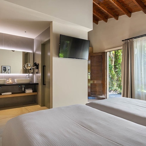 a bathroom with two sinks and a flat screen tv