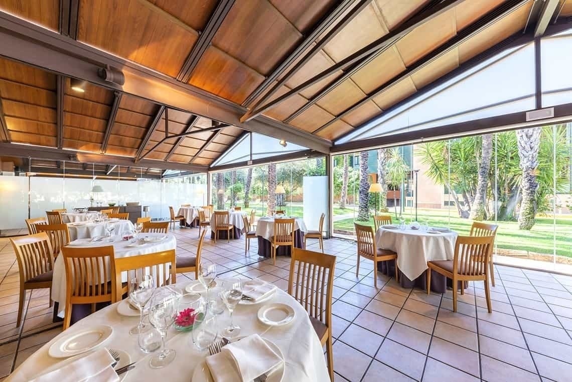 un restaurante con mesas y sillas y una pared de botellas de vino