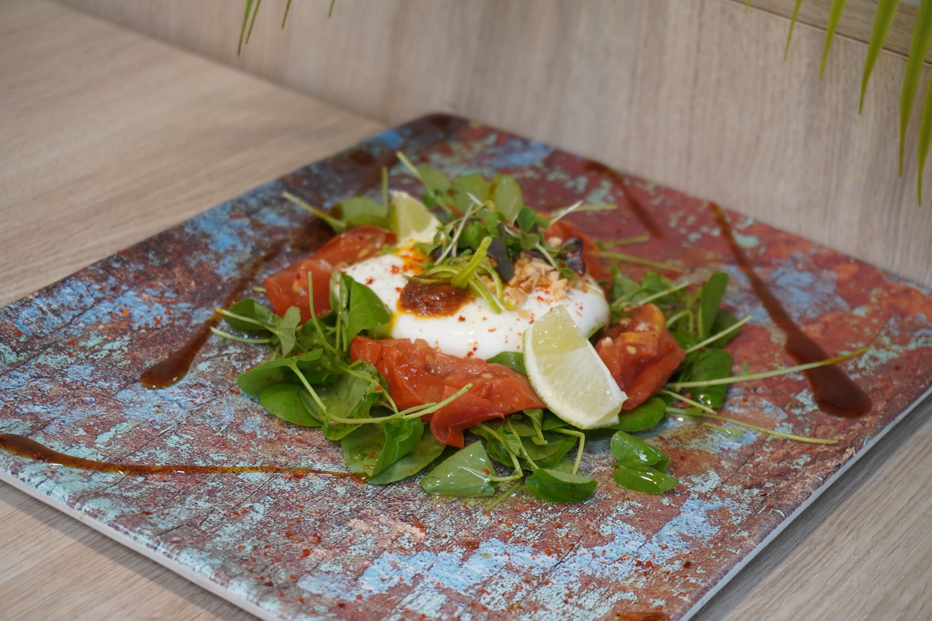 a plate of food with tomatoes and limes on it