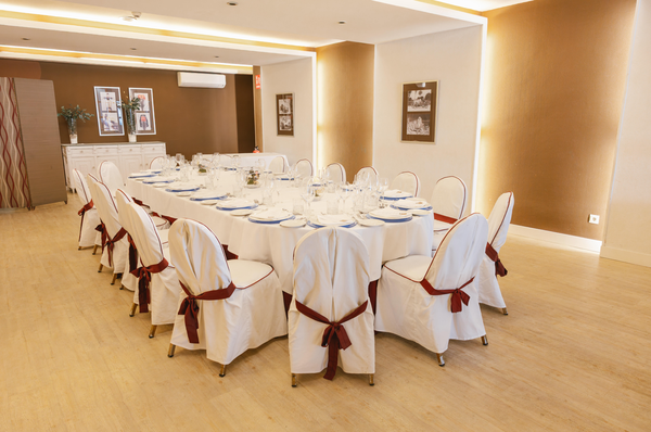 una sala de conferencias con mesas y sillas y una pantalla