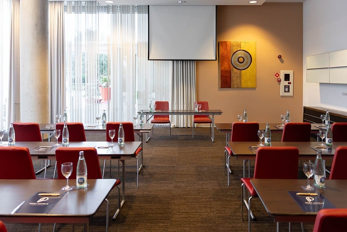 a conference room with tables and chairs and a projector screen