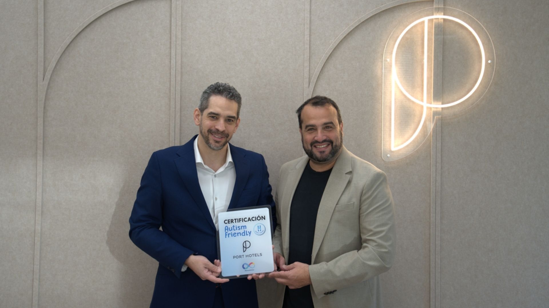 Dos hombres sonríen mientras sostienen un certificado de 