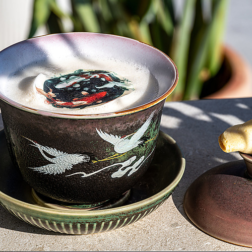 Taza de cerámica con grullas y peces koi, servida con galleta de la fortuna Port Hotels: Corporativa.