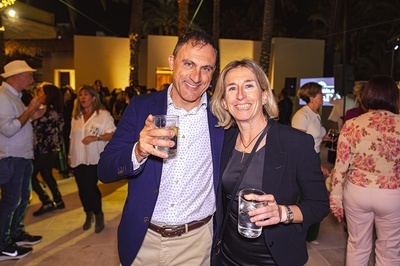 a man and a woman are posing for a picture while holding drinks - 