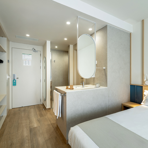 una habitación de hotel con una cama y un lavabo