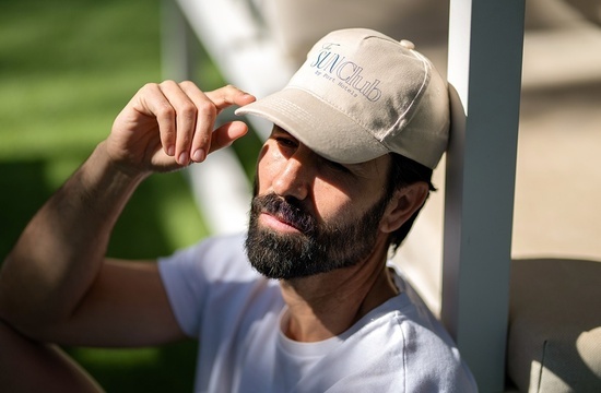 un hombre con barba lleva una gorra del club de sol