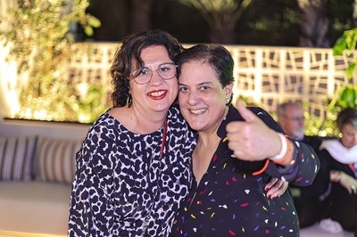 two women are posing for a picture and one is giving a thumbs up - 