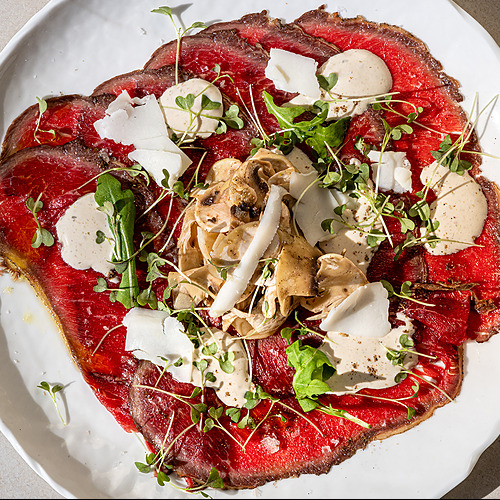 Carpaccio de res con champiñones, queso parmesano y rúcula Port Hotels: Corporativa