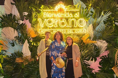 three women standing in front of a sign that says bienvenido al verano - 