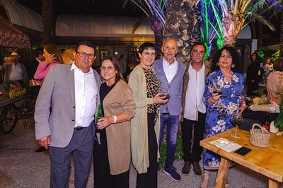 a group of people standing next to each other holding wine glasses - 