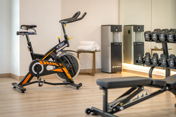 un gimnasio con una bicicleta está rodeado de espejos y pesas