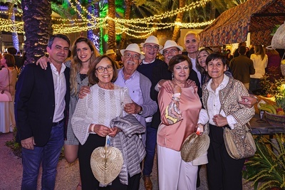 a group of people posing for a picture with one woman holding a fan - 