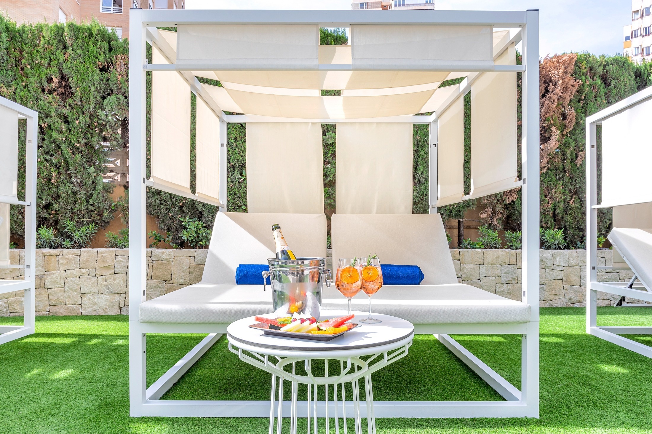 a canopy bed with a bucket of champagne and two glasses of orange juice