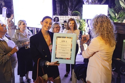 a woman holding a sign that says lote 2 - 