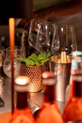 una mesa con vasos y botellas y un cubo de hielo - 