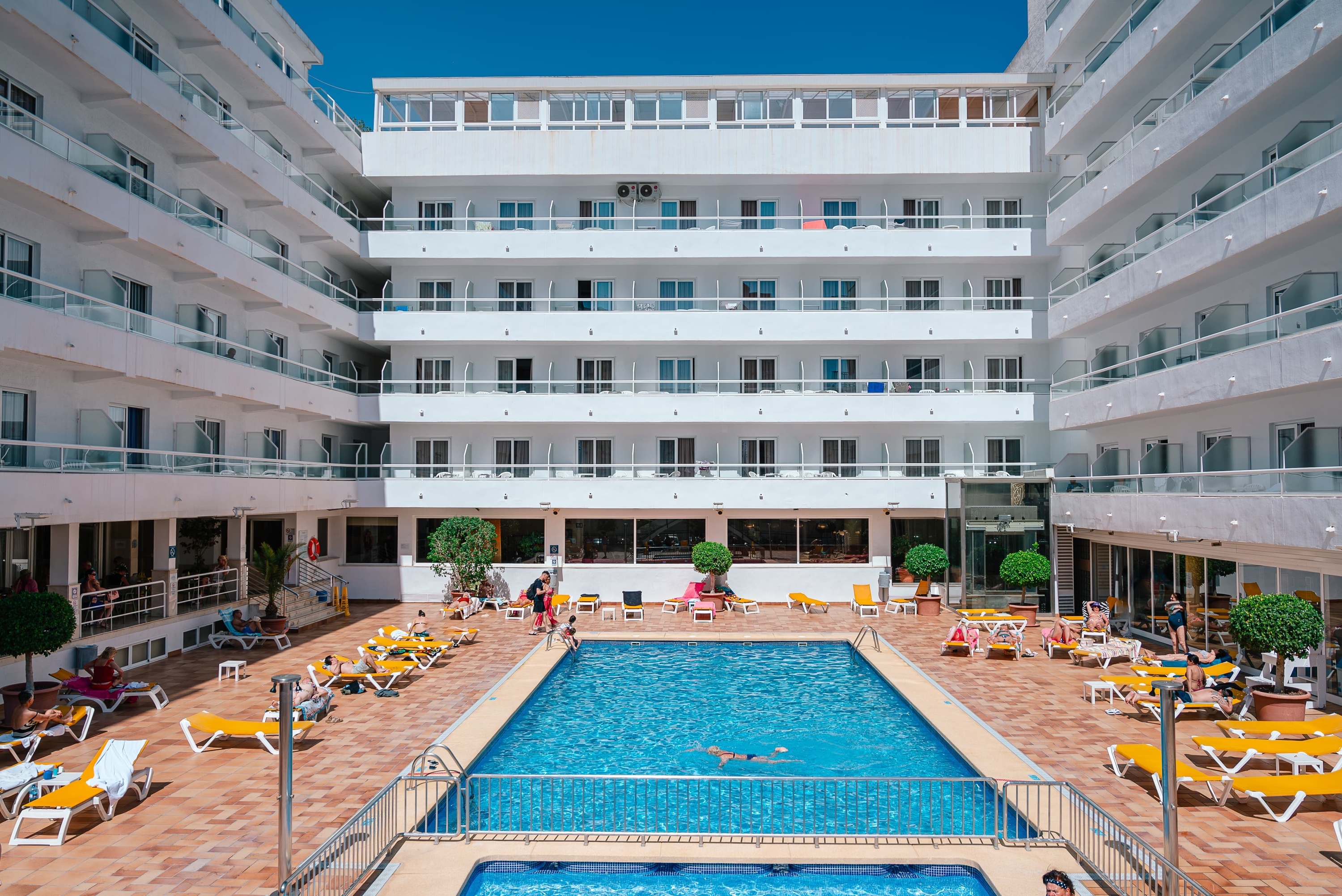 una piscina rodeada de sillas y balcones en un hotel