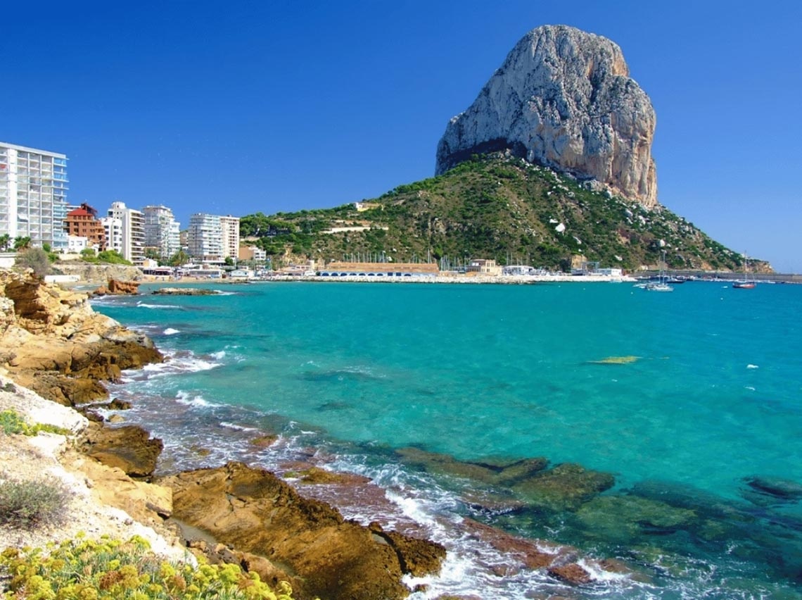 Port Hotels: Vista deslumbrante do mar azul turquesa com paisagem montanhosa e hotéis modernos.