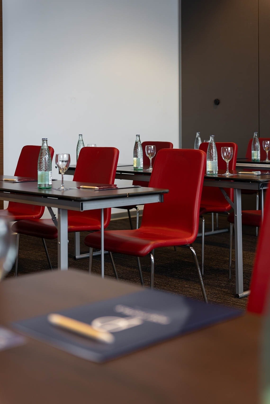 a conference room with red chairs and tables set up