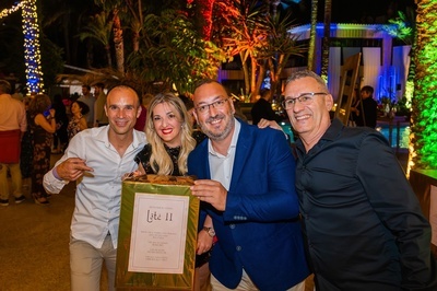un grupo de hombres y una mujer posan para una foto con una caja que dice lote 11 - 