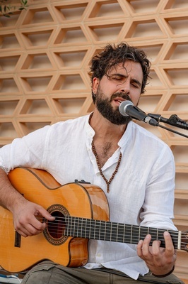 a man singing into a microphone while playing a guitar - 