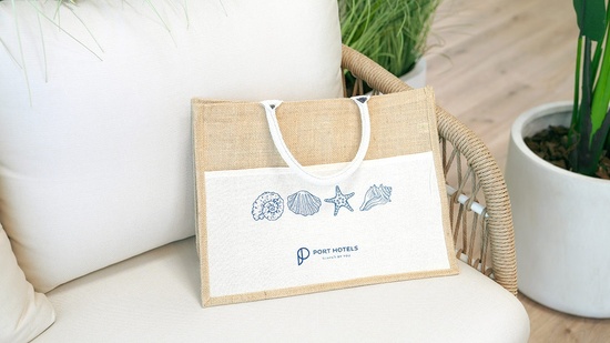 una bolsa con el logotipo de los hoteles del puerto está sentada en una silla