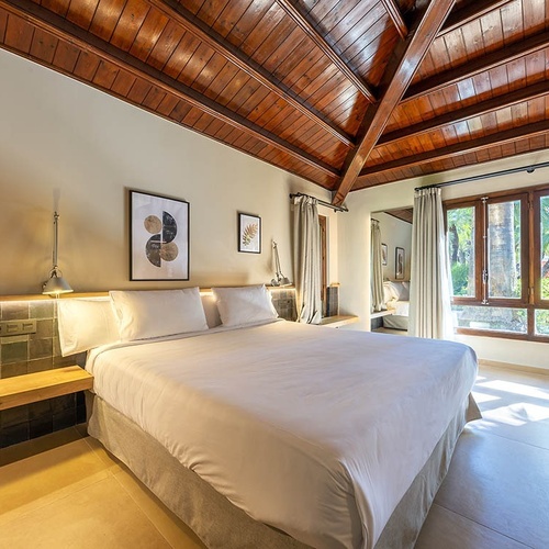 a bedroom with a wooden ceiling and a large bed