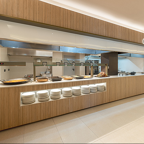 Buffet de comida variado en Port Hotels: Corporativa con platos apilados y un pavo asado.