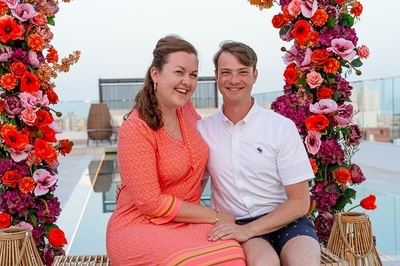 a man and a woman are posing for a picture with flowers in the background - 