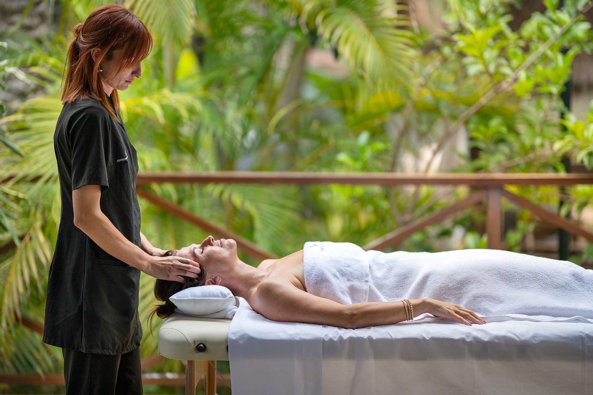 a woman laying on a table getting a head massage