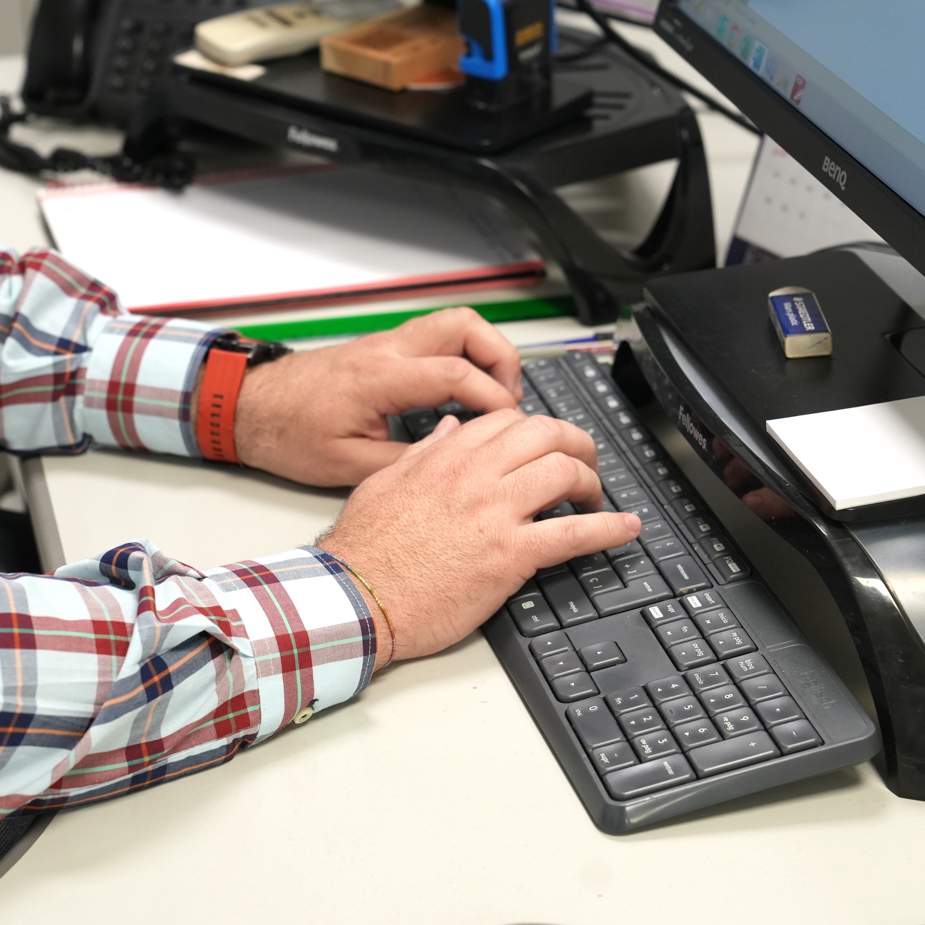 un hombre está escribiendo en un teclado benq