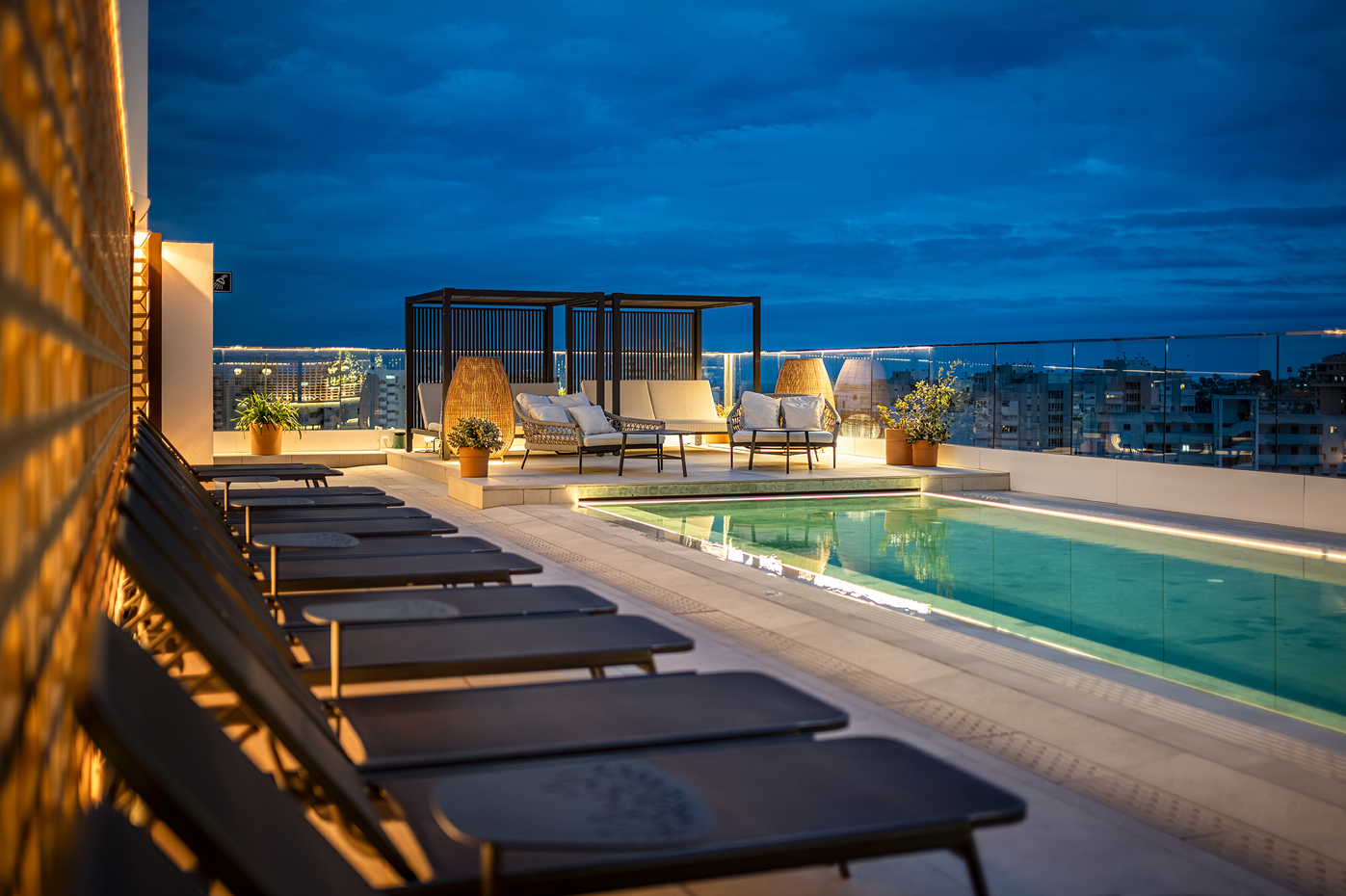 una piscina en la azotea de un edificio al atardecer